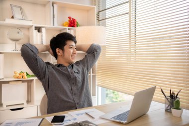 Genç adam işten sonra dinleniyor, gevşiyor, kendini esnetiyor..