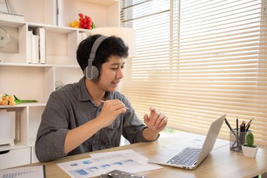 Evden Çalışan Adam, dizüstü bilgisayardaki müşterilerle video görüşmesi, Uzaktan İş İletişimi, Profesyonel Telekomünikasyon, Ofis Müşterisiyle Sanal Video Görüşmesi, Ev Konseptinden İş.