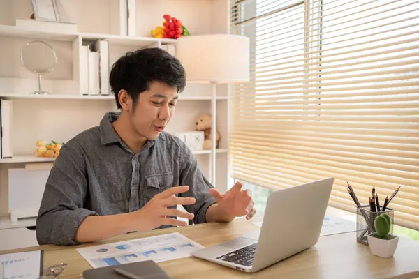Man Working from Home, Video call with customers on laptop, Remote Business Communication, Telecommuting Professional, Virtual Video Call with Office Customer, Work from Home Concept.