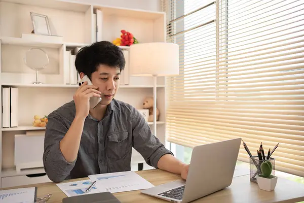 Young male businessman talks on the phone with a customer to negotiate business, Long distance communication, Negotiating a Business Deal via Phone Call.