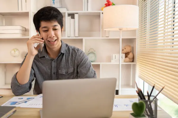 Young male businessman talks on the phone with a customer to negotiate business, Long distance communication, Negotiating a Business Deal via Phone Call.