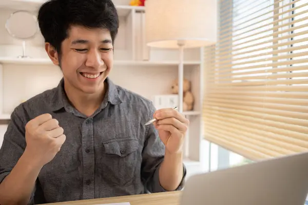 Son derece mutlu, gülümseyen genç adam sınavları geçmekten ya da iyi notlardan memnun ya da şaşırmış başarılı olmak seni mutlu ediyor, gülümsüyor ve başarı için bağırıyor, kazanan hareketi yapıyor, evet..