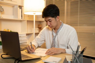 İşadamı veri grafiklerini analiz eder ve özenle kişisel ofisinde çalışır, gecenin bir yarısı fazla mesai yapar..