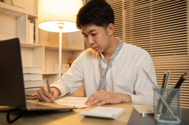 İşadamı veri grafiklerini analiz eder ve özenle kişisel ofisinde çalışır, gecenin bir yarısı fazla mesai yapar..