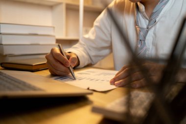 Gecenin bir yarısı çalışırken, bir deftere önemli notlar yazarken yakın çekim..