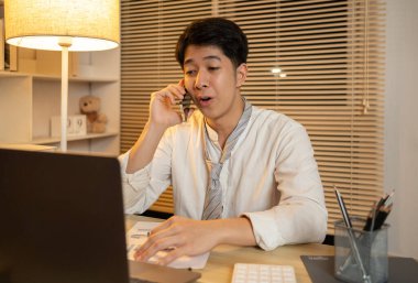 Telefonda konuşan işadamı iş görüşmesi yapmak, şehirlerarası iletişim kurmak, telefon aracılığıyla iş görüşmesi yapmak, gece yarısı çalışmak için bir müşteriyle konuşuyor..