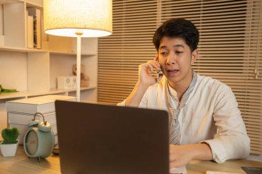 Telefonda konuşan işadamı iş görüşmesi yapmak, şehirlerarası iletişim kurmak, telefon aracılığıyla iş görüşmesi yapmak, gece yarısı çalışmak için bir müşteriyle konuşuyor..