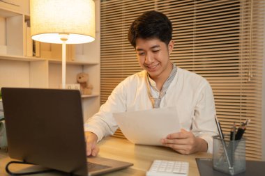 Gecenin bir yarısı çalışan işadamı, veri grafiklerini analiz eder ve kişisel ofisinde, ofiste çalışan çalışanları dikkatle inceler..