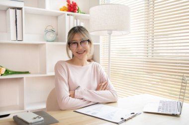 Genç bir kadın bilgisayar masasında çalışıyor, gülümseyen genç bir adam hafta başında işe hazır, ev için çalışıyor..