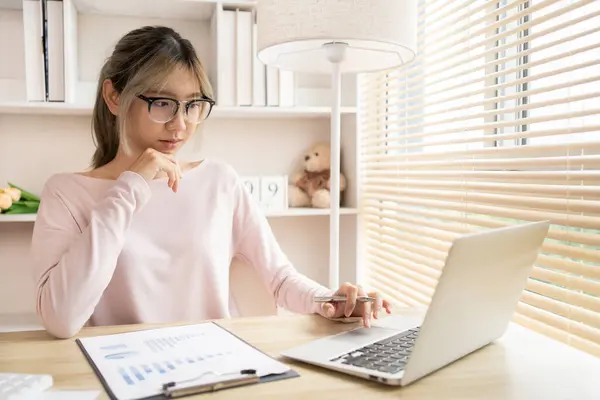 Young woman using a laptop, Work from the comfort of home, Use your laptop for work and communication, Work from home.
