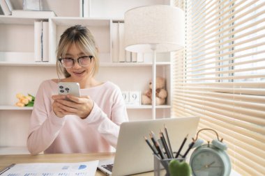 Gülümseyen yüzüyle telefonda yazan genç bir kadın, Dijital İletişim, internet ağının akıllı telefonuyla konuşma..