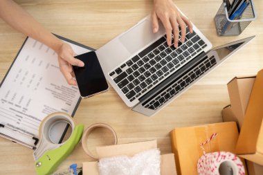 İnternetten ürün satma, el ele tutuşmanın ve dizüstü bilgisayarın aynı anda kullanılması, çevrimiçi bir iş için ürün paketleme, ev işi gibi ekipmanlarla çalışma..