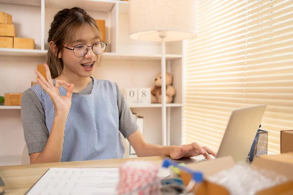 Sell products online, Young women are doing live or video calls with customers to place orders and prepare for delivery, Make The Ok Hand Sign to confirm and accept the order.