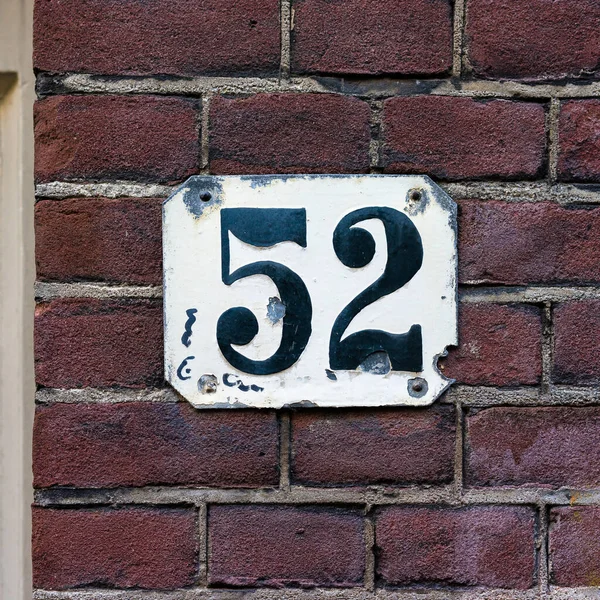 house number fifty two. Black numerals on a white plate