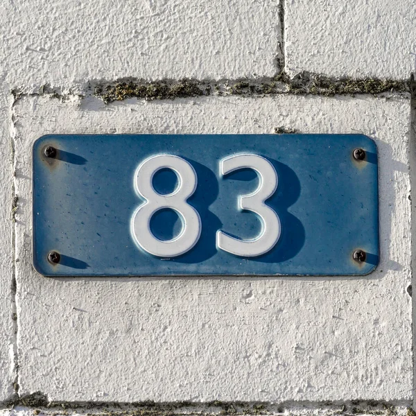 家の番号は83 ブループレートにエンボス加工されたホワイトフォント — ストック写真