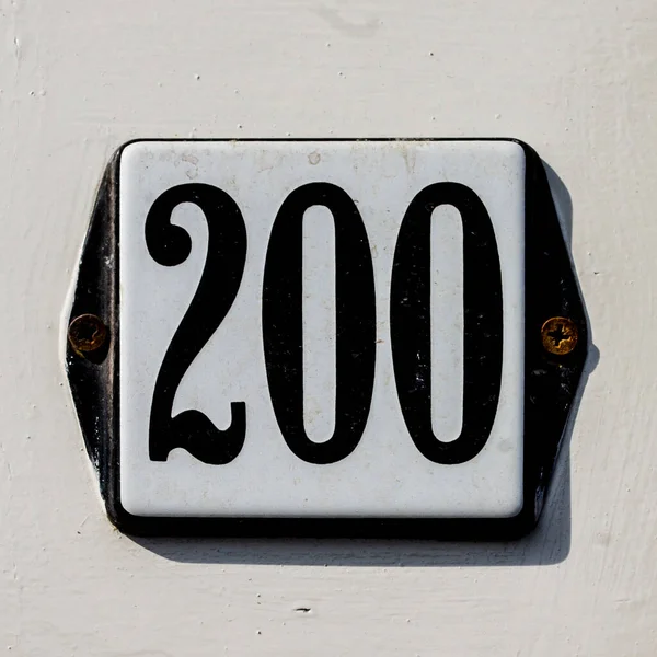 涂有两个螺钉的搪瓷板上的200号房子 — 图库照片