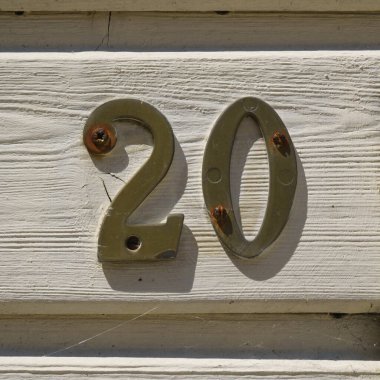 20 (20) numaralı pirinç ev tahtadan bir panelde.