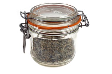 Beyaz arka planda bir kavanoz tarhun yakın yakın; Bocal d 'estragon en gros plan sevilen blanc