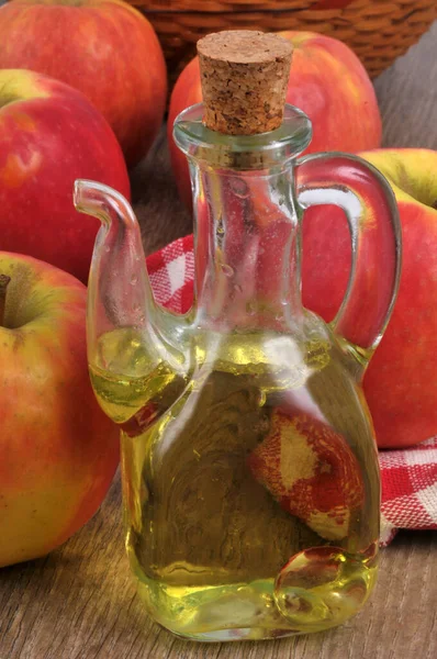 Carafe of apple vinegar with apples close-up