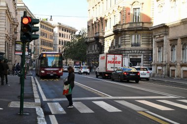Zebra sırtında bir kadın Roma 'da Corso Vittorio Emanuele' yi geçiyor ve arkasında bir otobüs var. 