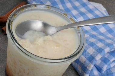 Pirinç pudinginin ramekin 'i ve yakın plan kaşığı.