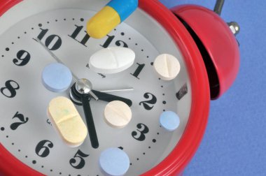 Çalar saatin kadranında bulunan çeşitli uyuşturucular. Kapatın.