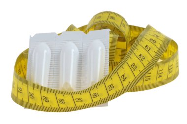 Fitillerde müshil içeren kabızlık kavramı ve beyaz arka planda esnek bir metre. 