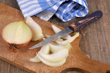 Kesme tahtasındaki soğanı yakın plan bıçakla kes.