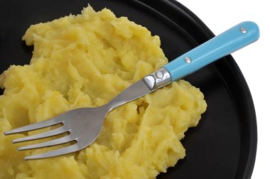 Plate of buttered mashed potatoes with smoked sausage close-up on white background