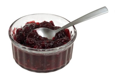 Beyaz arka planda bir kaşıkla vişne reçeli ramekin