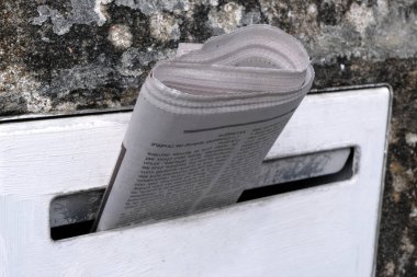 Newspaper in a mailbox close up