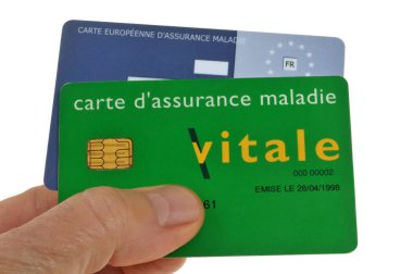 Vitale kartı ve Avrupa sağlık sigortası kartı beyaz arka planda el ele tutulur.