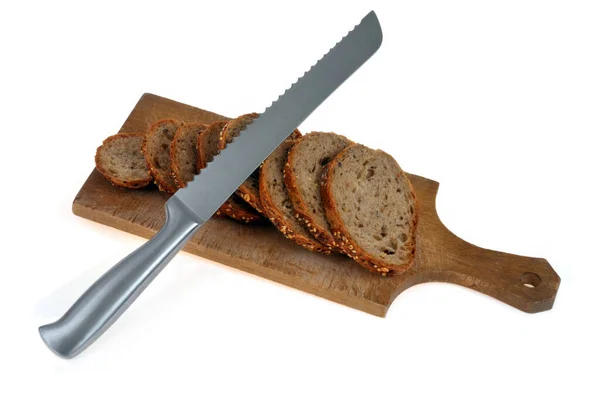 白を基調としたナイフで木製のまな板に種パンをスライス — ストック写真