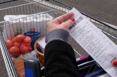 Faturası yakın ve arka planında tam bir süpermarket tramvayı olan bir güç satın alma kavramı