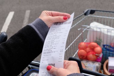 Faturası yakın ve arka planında tam bir süpermarket tramvayı olan bir güç satın alma kavramı