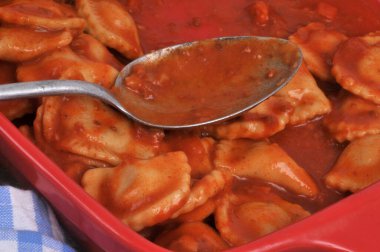 Domates soslu ravioli tabağı kaşıkla yakın plan.