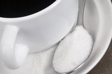 Bir fincan kahve ve bir kaşık pudra şekeri.