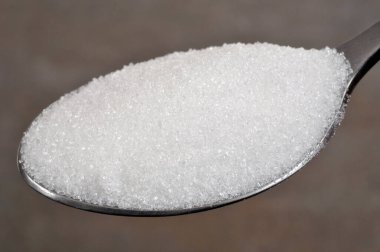 Gri arka planda yakın plan pudra şekeri kaşığı