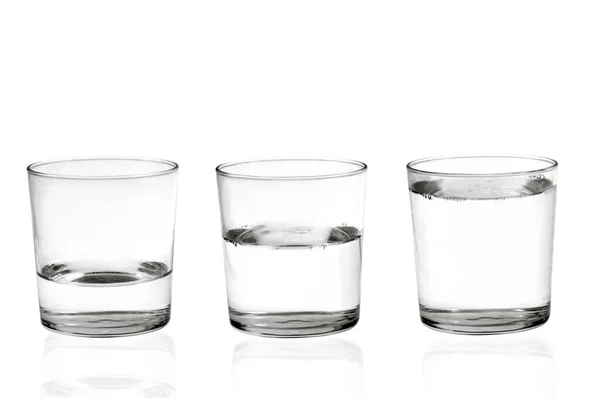 白い背景に異なるレベルのクローズアップ水で満たされた3つのメガネ — ストック写真