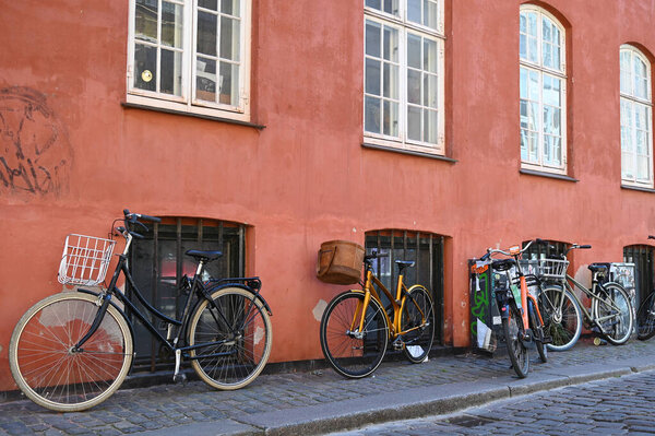 Bicycles leaning against the wall of a house in a street in Copenhagen
