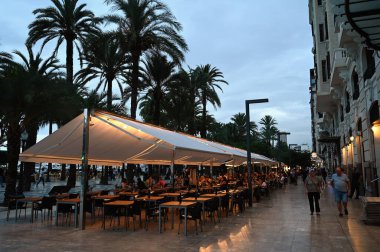 Akşamın erken saatlerinde Alicante 'nin Ramblas' ında restoran terasları 