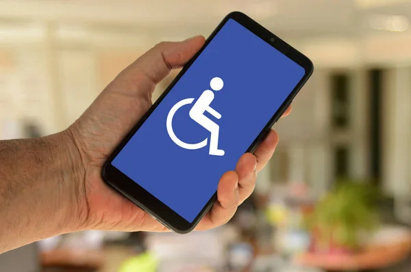 Smartphone Hand Met Handicap Symbool Weergegeven Het Scherm Rechtenvrije Stockafbeeldingen