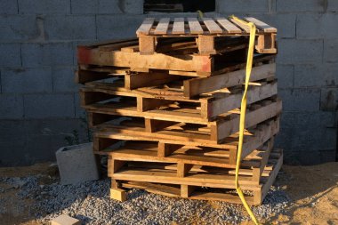 Ahşap paletler bir inşaat sahasına istiflenmiş. 