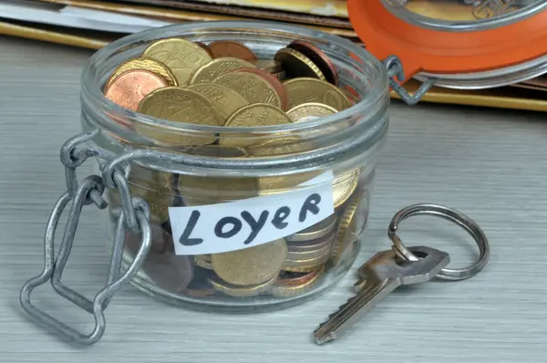 Jar filled with euro coins for rent with a housing key