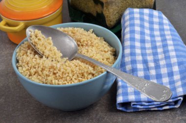 Bir kase bulgur, kaşık ve peçeteyle yakın plan.