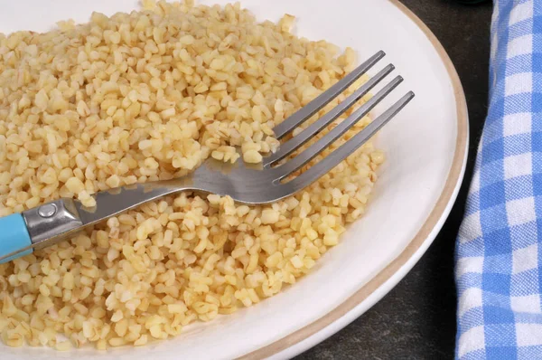 Yakından çatalla pişirilmiş bulgur tabağı.