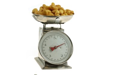 Grenaille patatesleri mutfak terazisinde yakın plan beyaz arka plan 