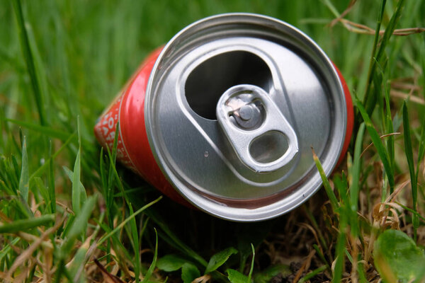 Пустая банка газировки, брошенная в траву 