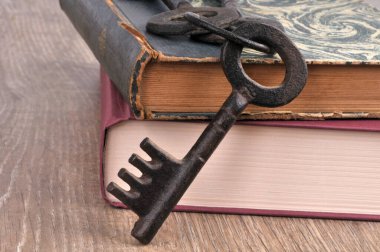 Kitapların üzerinde duran eski anahtarlar.