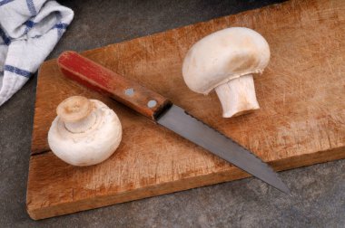 Kesme tahtasına yakın plan bıçaklı düğme mantarları 